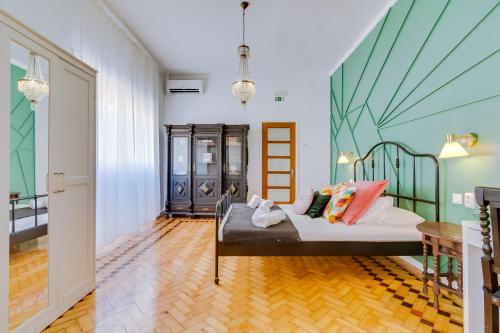 a room with a bed with colorful pillows on it at À da Avó -The Guesthouse in Faro
