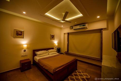 a bedroom with a bed and a projection screen at SHARVARI BEACH HOME STAY at Mangalore by Vaishnavi Reveries in Mangalore