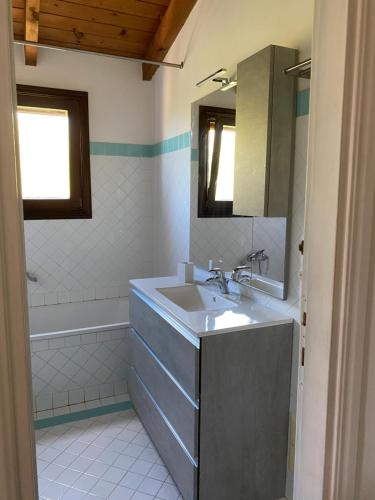 a bathroom with a sink and a tub at Carolina Apartment in Stintino