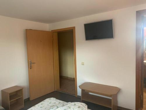 1 dormitorio con 1 cama y TV en la pared en Pensiunea Floare de Colt, en Deva