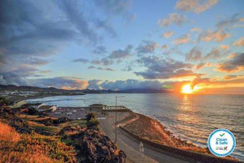 a sunset over the ocean with the sun setting at Matriz Sunset View in Ribeira Grande