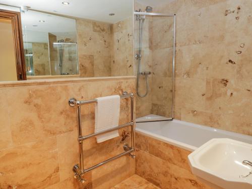a bathroom with a shower and a tub and a sink at Dale View in Whitby
