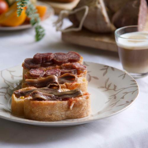 een bord met een broodje op een tafel met een glas melk bij Hotel Boutique Niu de Sol - Designed for Adults in Palau-Saverdera