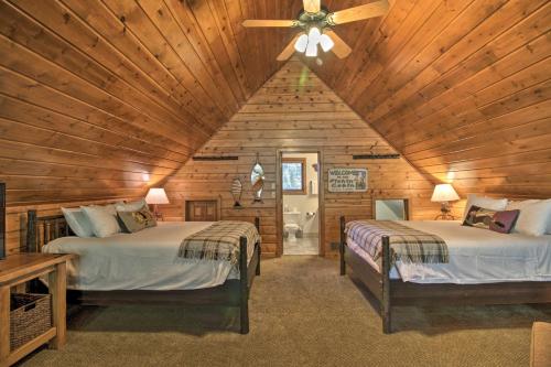 Dormitorio en cabaña de madera con 2 camas y ventilador de techo en Alluring Nisswa Cabin on Gull Lake with Fireplace!, en Nisswa