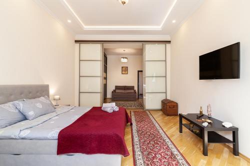 a bedroom with a bed and a flat screen tv at Apartment on Tamanskaya 3/4 in Lviv