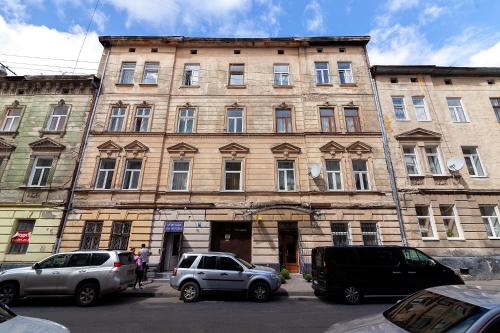an old building with cars parked in front of it at Apartment 3, room 4, Tamanska, Дарії Гусяк in Lviv