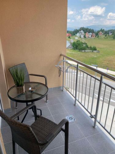 a balcony with a table and chair and a view at Pinnacle MNE in Žabljak