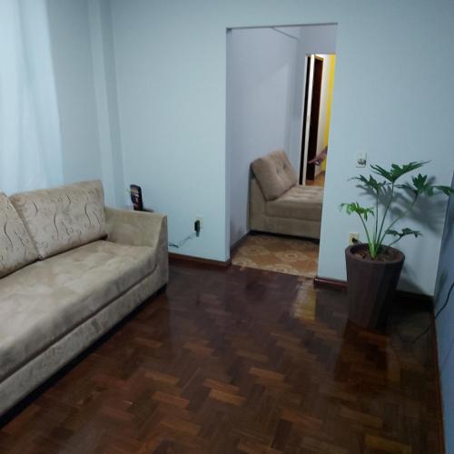 uma sala de estar com um sofá e uma cadeira em Apartamento Aconchegante em Divinópolis