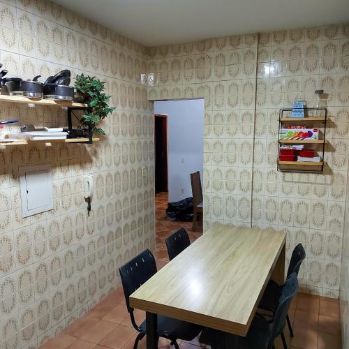 uma sala de jantar com uma mesa de madeira e cadeiras em Apartamento Aconchegante em Divinópolis