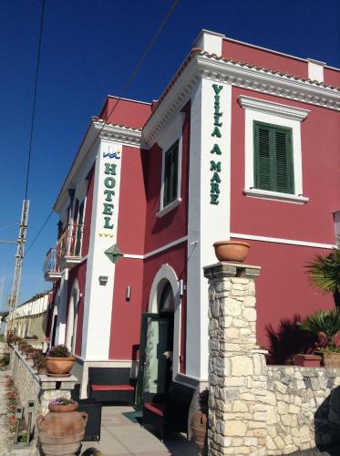 a red and white building withcriptions on it at Hotel Villa A Mare in Rodi Garganico