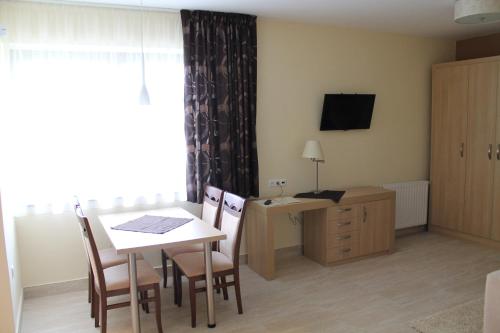 a room with a table and chairs and a desk at Tiffán's Pincészet és Panzió in Villány