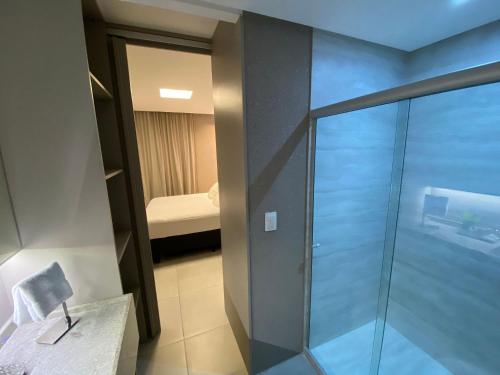 ein Bad mit einer Glasdusche und ein Schlafzimmer in der Unterkunft Edifício Time Apto 916 ER Hospedagens in Maceió