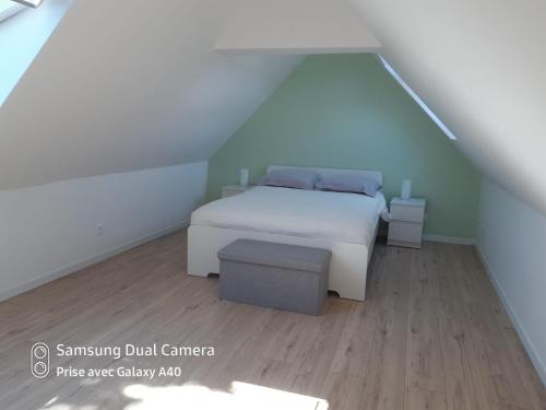 a bedroom with a white bed and a wooden floor at Maison entre Mer et Brière. Proche de La Baule et de Guérande. in Saint-André-des-Eaux