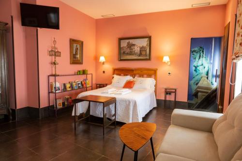 a hotel room with a bed and a couch at Palacio Sirvente Mieres - PARKING GRATUITO in Andújar