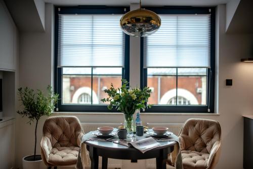 jadalnia ze stołem, 2 krzesłami i oknem w obiekcie Apartamenty Stare Miasto Zamość w mieście Zamość