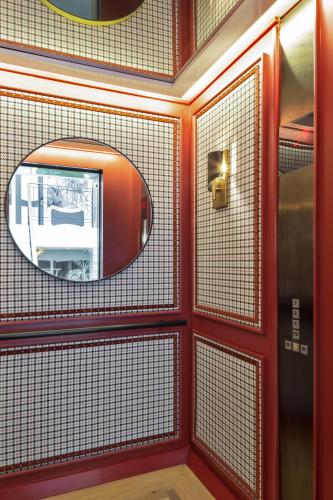 a bathroom with a mirror and red walls at The Alest Hotel in Mexico City