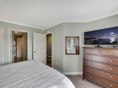 a bedroom with a large bed and a dresser at Beach Room 214 in Traverse City