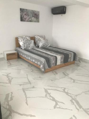 a bed in a room with a marble floor at Casa Bacestianu in Buzău