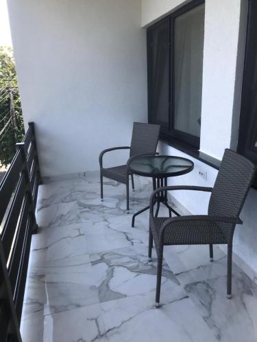 a balcony with two chairs and a table and a window at Casa Bacestianu in Buzău