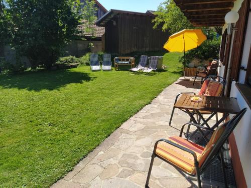 a patio with chairs and a table with an umbrella at Opas Bergchalet in Halblech