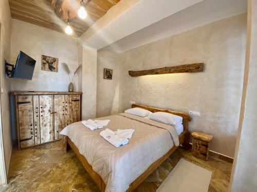 a bedroom with a bed with towels on it at Noclegi - Karczma Solina in Solina
