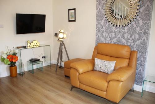 a living room with a chair and a television at City Centre Town House with Riverside Views and Free Parking 1BAK in York