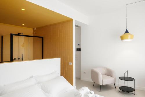 a bedroom with a bed and a chair and a mirror at Malalbergo in Reggio Calabria