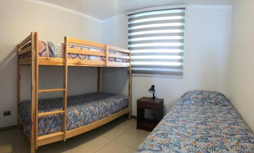1 dormitorio con 2 literas y ventana en Marina Horizonte II - Free Parking, en Coquimbo