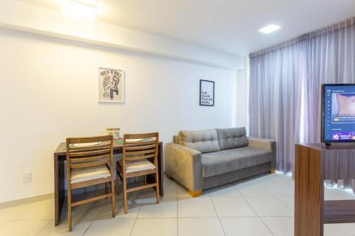 a living room with a table and a couch and a television at Beach Class Santa Maria by Easy Home in Recife
