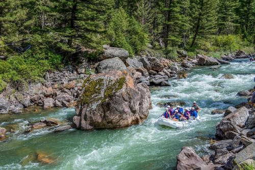 a group of people in a raft on a river at Huntley Lodge at Big Sky Resort in Big Sky