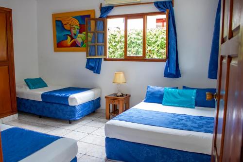 1 dormitorio con 2 camas y ventana en HC Liri Hotel, en San Juan del Sur