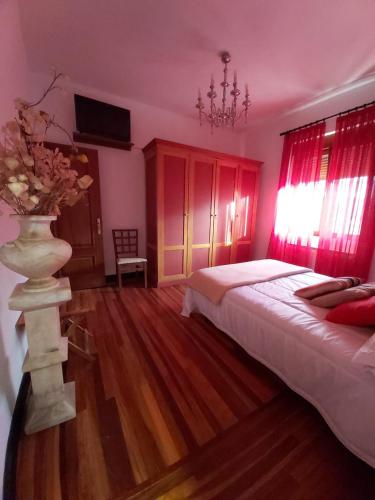 a bedroom with a bed and a vase with flowers in it at GARDEN ROOMS in Castro-Urdiales