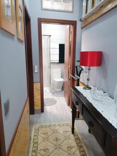 a bathroom with a desk with a red lamp on it at Casinha da Mó in Vieira do Minho