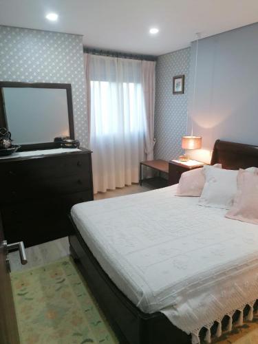 a bedroom with a large bed and a mirror at Casinha da Mó in Vieira do Minho