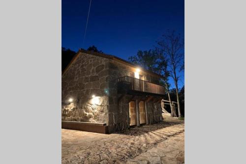 a stone building with lights on it at night at Formas Patuscas, Turismo Rural in Gouveia