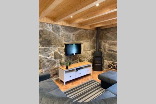 a living room with a stone wall at Formas Patuscas, Turismo Rural in Gouveia