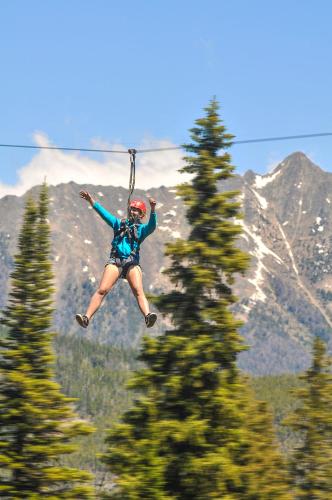 a woman jumping in the air on a zip line at Summit Hotel at Big Sky Resort in Big Sky