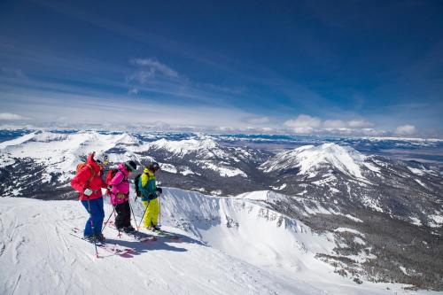 a group of people standing on top of a snow covered mountain at Summit Hotel at Big Sky Resort in Big Sky