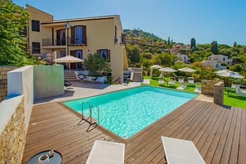 a swimming pool on a wooden deck next to a house at Pater Meus Suites in Cefalù