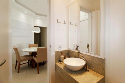baño con lavabo en una encimera con mesa en 1081 - Praia de Bombinhas locação de temporada, en Bombinhas