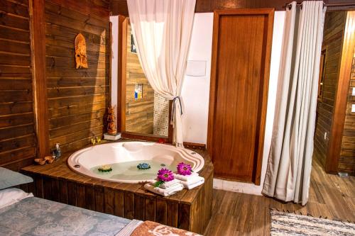 uma casa de banho com banheira e uma cama. em Shiva Guest House em Florianópolis