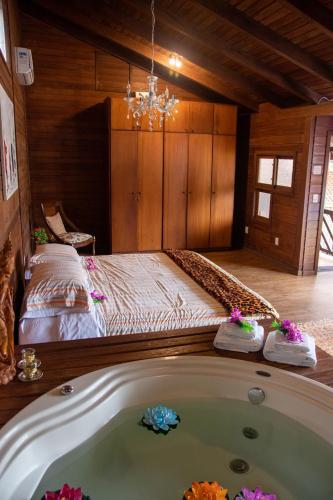 a bedroom with a bed and a bath tub at Shiva Guest House in Florianópolis