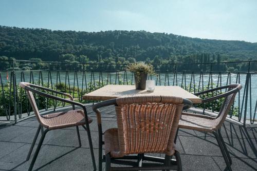 a table and chairs on a balcony with a view of the water at Leutesdorfer Hof in Leutesdorf