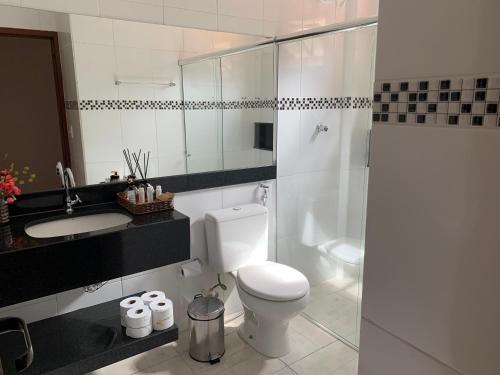 a bathroom with a toilet and a sink and a shower at Flor de Café Pousada in Pedra Menina