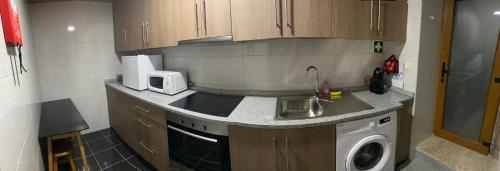 a kitchen with a sink and a washing machine at Casa das Flores in Lamego