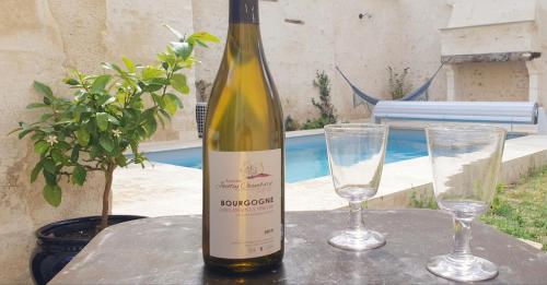 a bottle of wine sitting on a table with two glasses at La Croix au Maitre in Coulanges-la-Vineuse