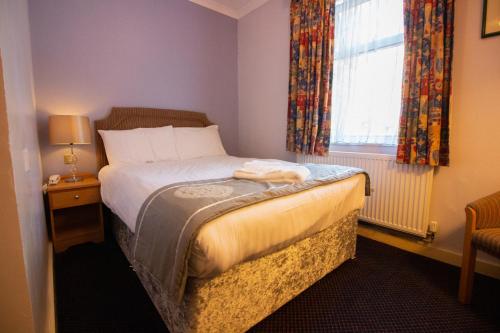 a small bedroom with a bed and a window at Westone Manor Hotel in Northampton