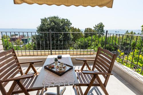 a table and chairs on a balcony with a view of the ocean at MENAR HOTEL&SUITES -Old City Sultanahmet in Istanbul