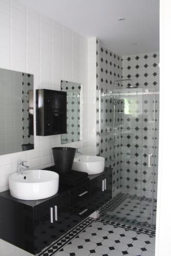 a bathroom with two sinks and a glass shower at dreamingzeeland in Nieuwvliet