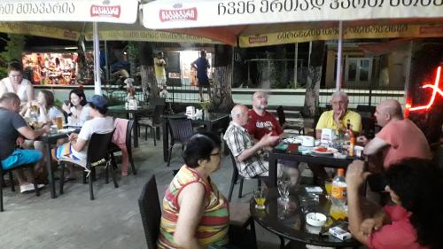 a group of people sitting at tables in a restaurant at Apartment Zhemchuzhina Ureki in Ureki